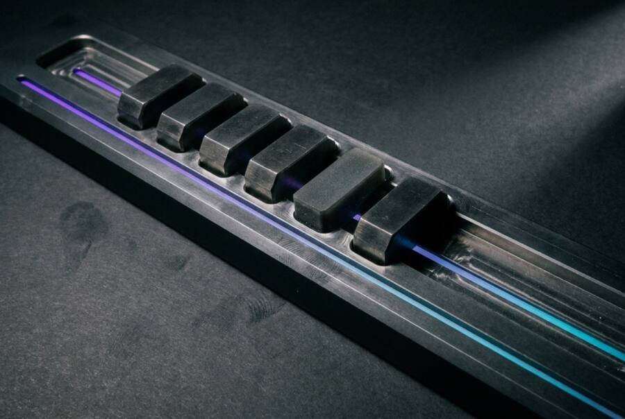 A row of equally spaced black blocks on a guide rail